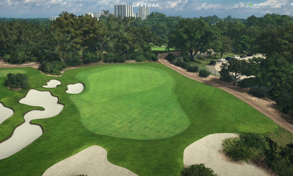 Golf course with green fairway and sand bunkers, surrounded by trees.